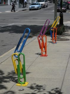 there are several colorful paper clips on the sidewalk