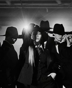 a group of people in suits and hats standing next to each other with their hands on their hipss