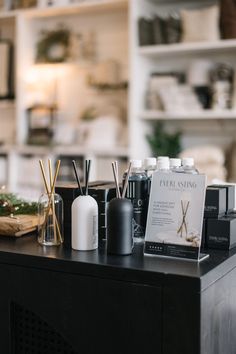 an assortment of personal care items sitting on a table in front of a bookshelf