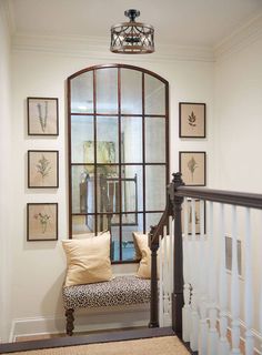 an entry way with a bench and pictures on the wall