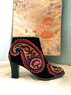 Short Silk Petit Point Boots from Uzbekistan with leather lining. These boots are created from hand drawn designs on cotton canvas, inspired by original designs from ancient Uzbekistan textile history. Height measures 6" with a 3" heel. Size 38 (US 8) available. 100% silk petit point with leather lining with leather sole. Zip closure. Handmade in Uzbekistan. Your purchase preserves and encourages Folk Art Traditions in Uzbekistan, enabling women, families and communities to preserve their traditions and contributes to the health and well being of the communities at large. Your purchases helps a long chain of women working hard to preserve our dignity and integrity to live in a world that recognizes creativity in it's many forms and rewards it with your support.  Thank you for your support. Textile History, Pointed Boots, Womens Booties, Embroidered Boots, Embroidered Shorts, Boho Festival, Long Chain, Boot Shoes Women, Needlepoint