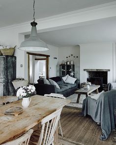 a living room filled with furniture and a fire place next to a dining room table