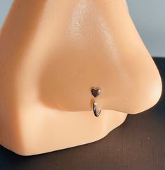 a close up of a plastic head with a heart on it's earring