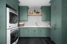 a kitchen with green cabinets and tile flooring, including a washer and dryer