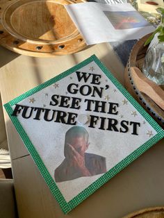 a graduation cap with the words we go see the future first on it sitting on a table