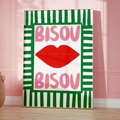 a pink and green striped room with a red lips poster on the wall in front of it