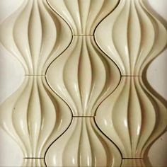 a white tile wall with wavy lines on the top and bottom part, in an abstract manner