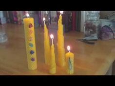 some yellow candles sitting on top of a wooden table