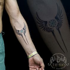 two people holding hands with tattoos on their arms