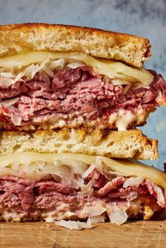 a close up of a sandwich on a cutting board with meat and cheese in it