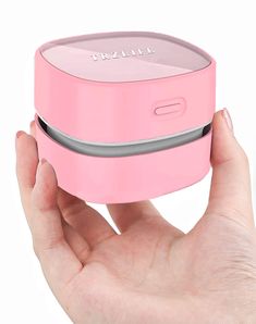 a hand is holding a pink portable speaker