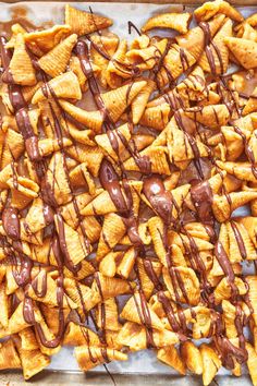 chocolate drizzled on the top of some tortilla chips in a baking pan