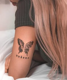 a woman with a butterfly tattoo on her left arm and the word endome written in black ink