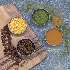 three bowls filled with different types of food on top of a wooden cutting board next to spices and seasonings