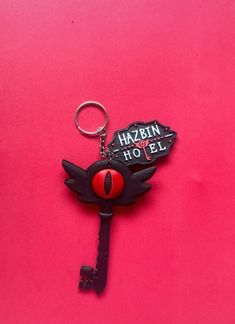 a black keychain with a red ball on it and the words habin hotel