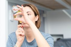 a woman is holding her hands up in front of her face and looking at the camera