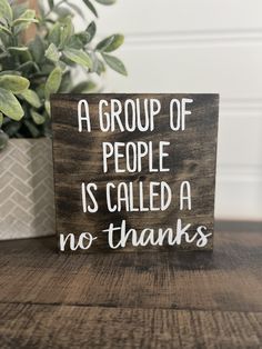 a group of people is called a no thanks sign on a wooden table next to a potted plant