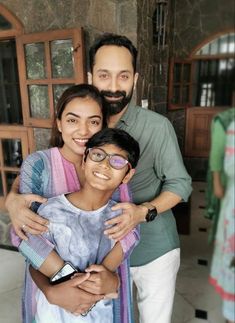 a man and woman are posing for a photo with a child in front of them