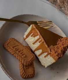 there is a piece of cake on the plate with a fork next to it and some cookies