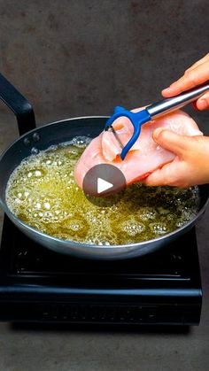 someone is using scissors to cut meat in a frying pan on top of an electric stove