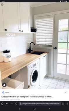 a kitchen with white cabinets and a washing machine