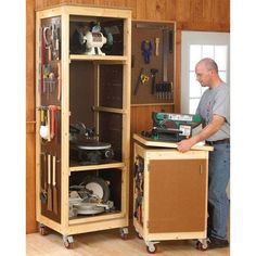 a man standing in front of a cabinet filled with tools