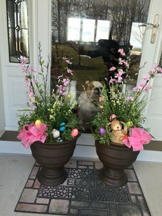 two potted plants with stuffed animals in them sitting on the front door mat next to each other