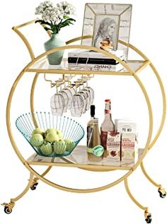 a gold bar cart with wine glasses, bottles and other items on it in front of a white background