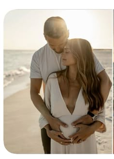 a man and woman standing next to each other on a beach