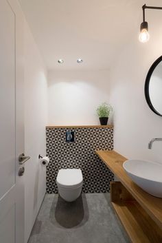 a bathroom with a toilet, sink and mirror on the wall next to each other