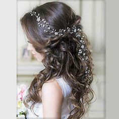 a woman with long brown hair wearing a wedding dress