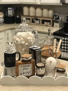 a tray with coffee mugs, marshmallows and other items on it