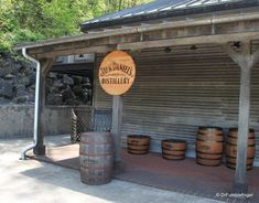 barrels lined up in front of a building with a sign that says town and country's distillacy