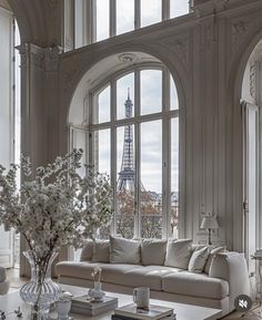 a living room filled with furniture and a large window overlooking the eiffel tower