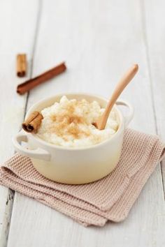 a white bowl filled with mashed potatoes and cinnamon on top of a pink napkin