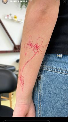 a woman's arm with a tattoo on it that has a flower drawn on it