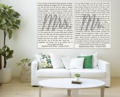 two white couches sitting next to each other in front of a wall with words on it