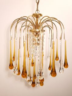 a chandelier hanging from the ceiling with lots of glass tubes attached to it