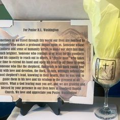 a wine glass sitting on top of a table next to a piece of paper that reads for pastor r l washington