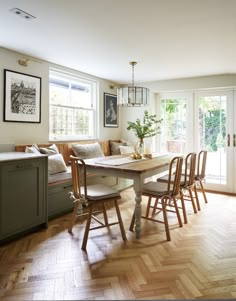 a dining room table surrounded by chairs and windows