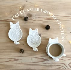 two knitted owls sitting next to a cup of coffee