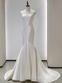 a white wedding dress on display in a room