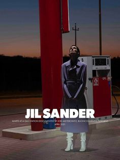 a woman standing in front of a gas pump