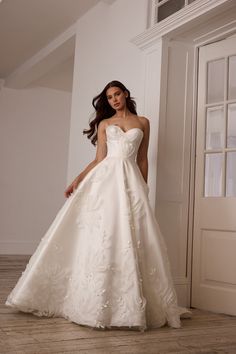 a woman in a white wedding dress posing for the camera