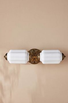 two light fixtures mounted on the side of a wall in a room with beige walls