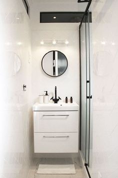 a bathroom with a sink, mirror and shower stall is shown in black and white