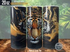 three different colored tiger mugs sitting on top of a wooden table