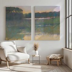 two paintings hang on the wall next to a white chair in a room with hardwood floors