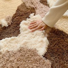 a person is touching an area rug on the floor with their hand and foot in it