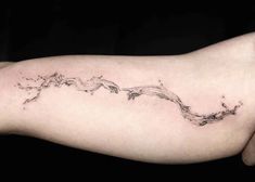 a woman's arm with a wave tattoo on the left side of her body